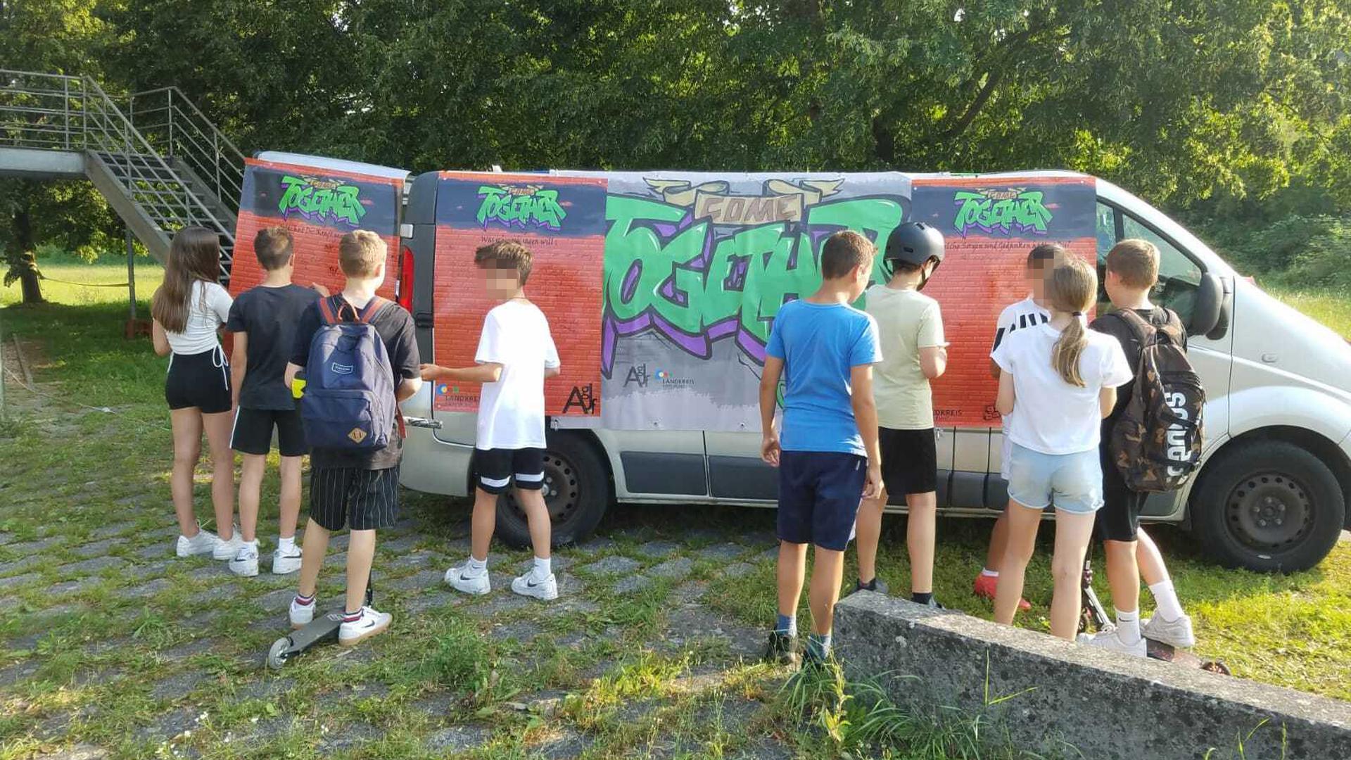 Busumfrage gestartet: Am Donnerstagabend schrieben Kinder und Jugendliche vor dem Kinder- und Jugendhaus in Berghausen ihre Ängste und Sorgen auf. 