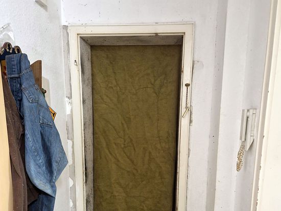 Not macht erfinderisch: Eine Decke musste vorübergehend als Ersatz dienen, nachdem ein Spezialeinsatzkommando die Wohnungstür aus den Angeln gesprengt hatte.