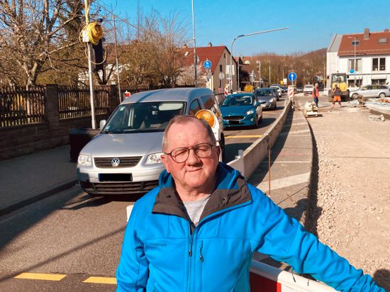 Ein älterer Mann steht vor einer Baustelle an der Ortsdurchfahrt der B293 in Berghausen, im Hintergrund staut sich der Verkehr.
