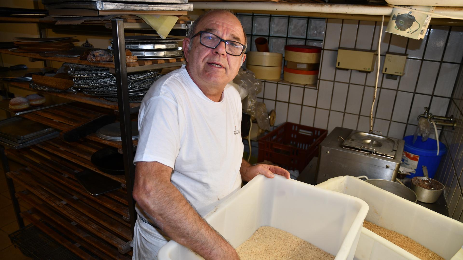 Bäcker Horst Friebolin wühlt in einem Bottich mit Semmelmehl.