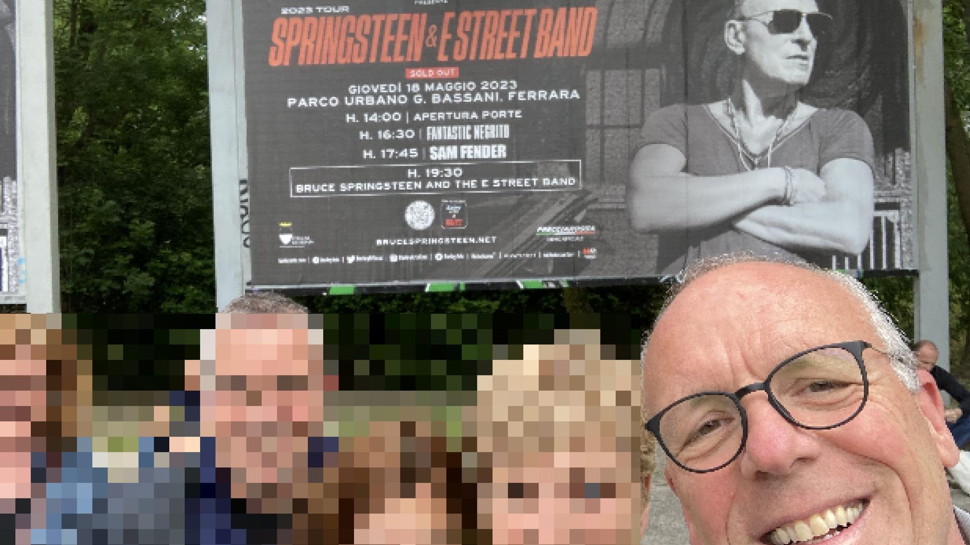 Menschen vor einem Plakat zum Springsteen-Konzert in Ferrara
