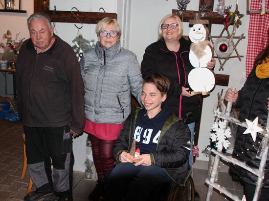 Der E-Bike-Vorbau für Toms Rollstuhl ist weitgehend gesichert. Dafür sorgen Elvira Hauser (Mitte) und ihre Familie.