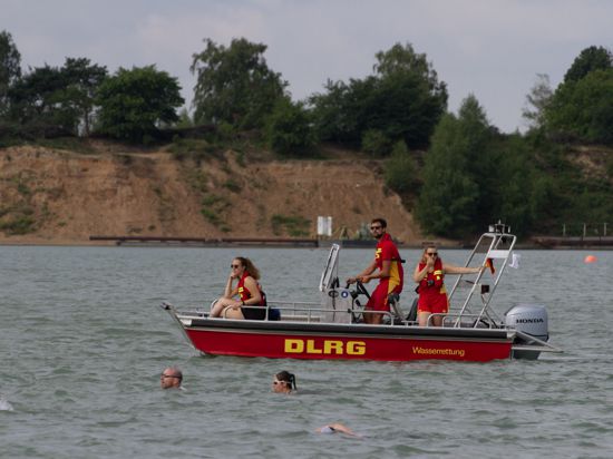 Boot mit Aufschrift DLRG und Schwimmer im Vordergrund