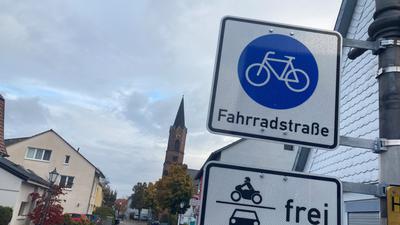 Ein Fahrradstraßenschild in der Adlerstraße in Rheinstetten-Forchheim. Im Hintergrund sieht man einen Kirchturm.