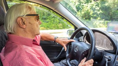 Älterer Herr mit Sonnenbrille am Steuer eines Mercedes. Wenn es nach dem Willen der EU geht, müssen Autofahrer ab 70 Jahren künftig regelmäßig auf ihre Fahrtauglichkeit geprüft werden.