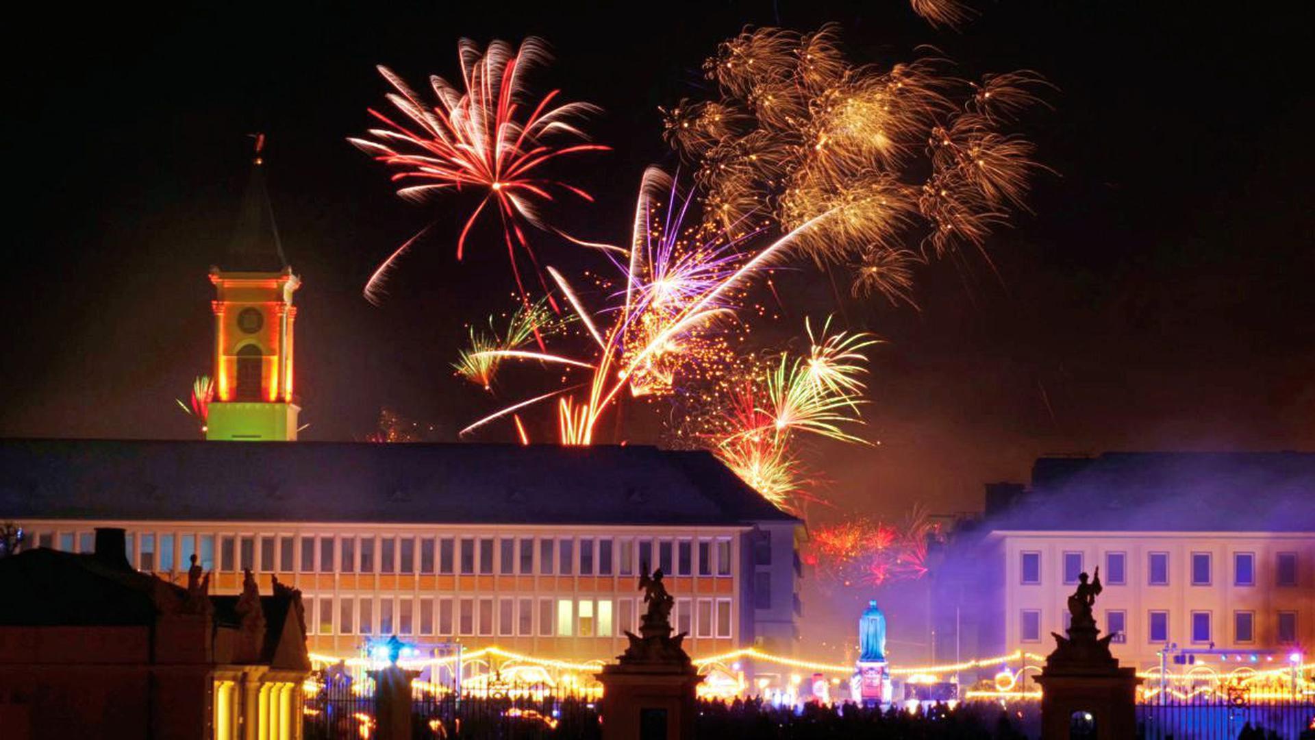 Etliche Menschen beobachteten das Silvesterfeuerwerk in Karlsruhe von der böllerfreien Zone am Schlossplatz aus.