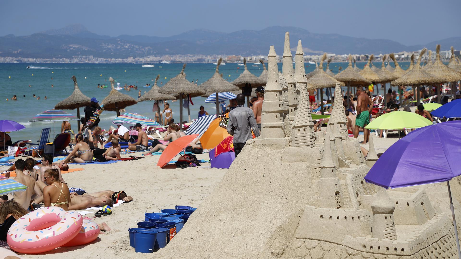 Touristen sonnen sich am Strand von El Arenal auf der Balearen-Insel Mallorca. Viele Touristen zieht es nach Spanien.