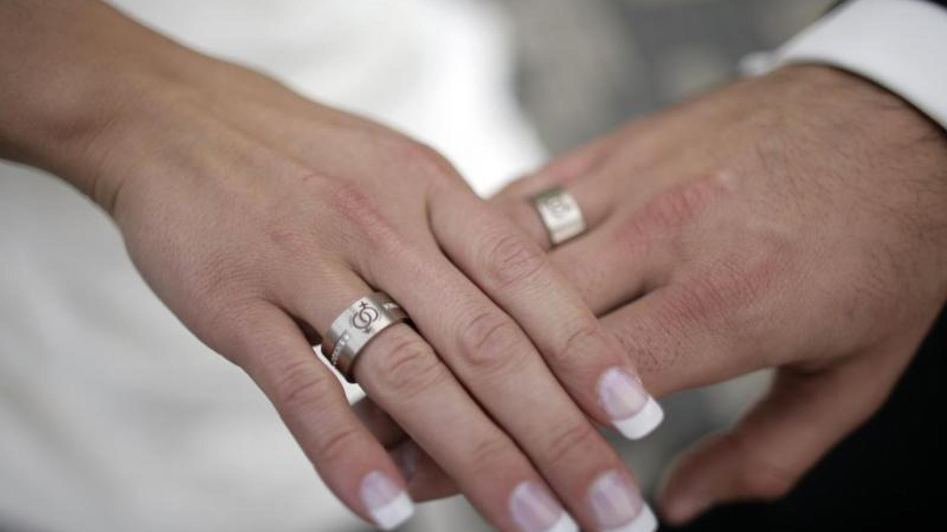 Ein Brautpaar legt nach dem Ringtausch die Hände übereinander