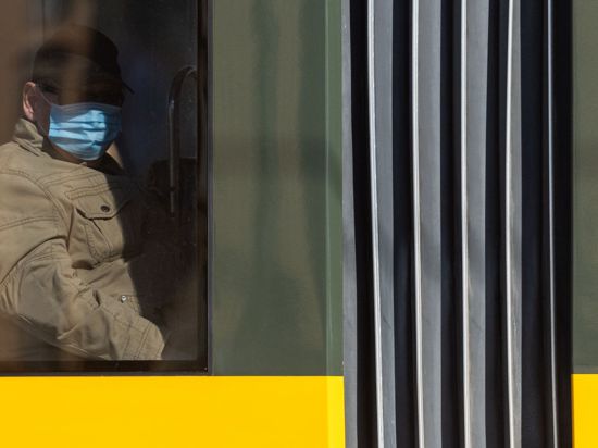 Ein Mann sitzt in der Straßenbahn und trägt einen Mundschutz.