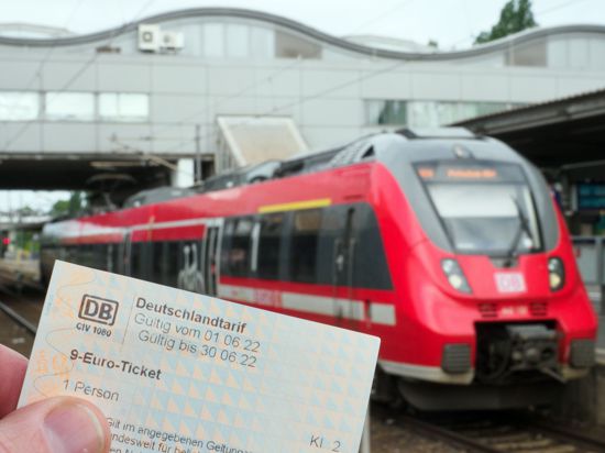 Ein Mann hält auf dem Potsdamer Hauptbahnhof ein 9-Euro-Ticket.