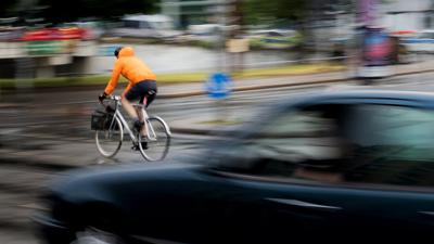 Ein Pkw fährt hinter einem Fahrradfahrer an einer Kreuzung einer Hauptverkehrsstraße in Berlin. Inwieweit Maßnahmen zur Verbesserung der Verkehrssicherheit befürwortet werden, hängt auch stark vom Alter ab.
