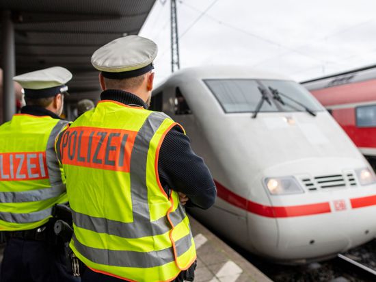 Zwei Beamte der Bundespolizei beobachten am Hauptbahnhof die Einfahrt eines ICE.