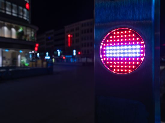 Ein Stop-Piktogramm an einer Rolltreppe leuchtet am späten Abend.