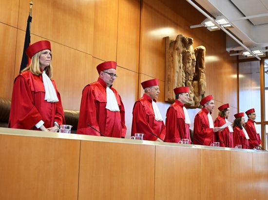 Die Mitglieder des Ersten Senats des Bundesverfassungsgerichts stehen vor der Urteilsverkündung hinter der Richterbank.