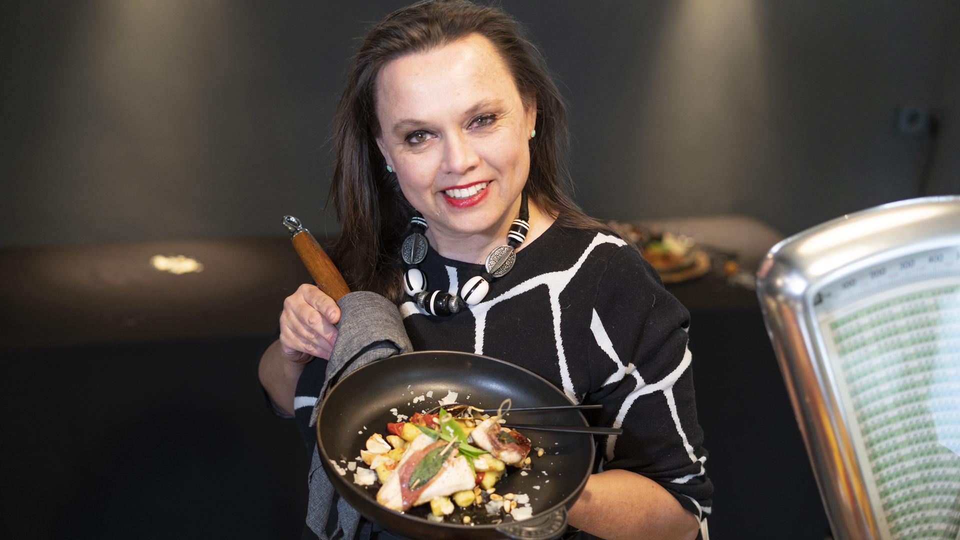 Köchin Stephanie Haller aus Kraichtal hält einen Teller mit Kraichgau-Forelle auf Bärlauch-Gnocchi in die Kamera.
