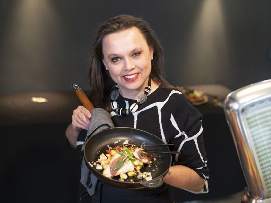 Köchin Stephanie Haller aus Kraichtal hält einen Teller mit Kraichgau-Forelle auf Bärlauch-Gnocchi in die Kamera.