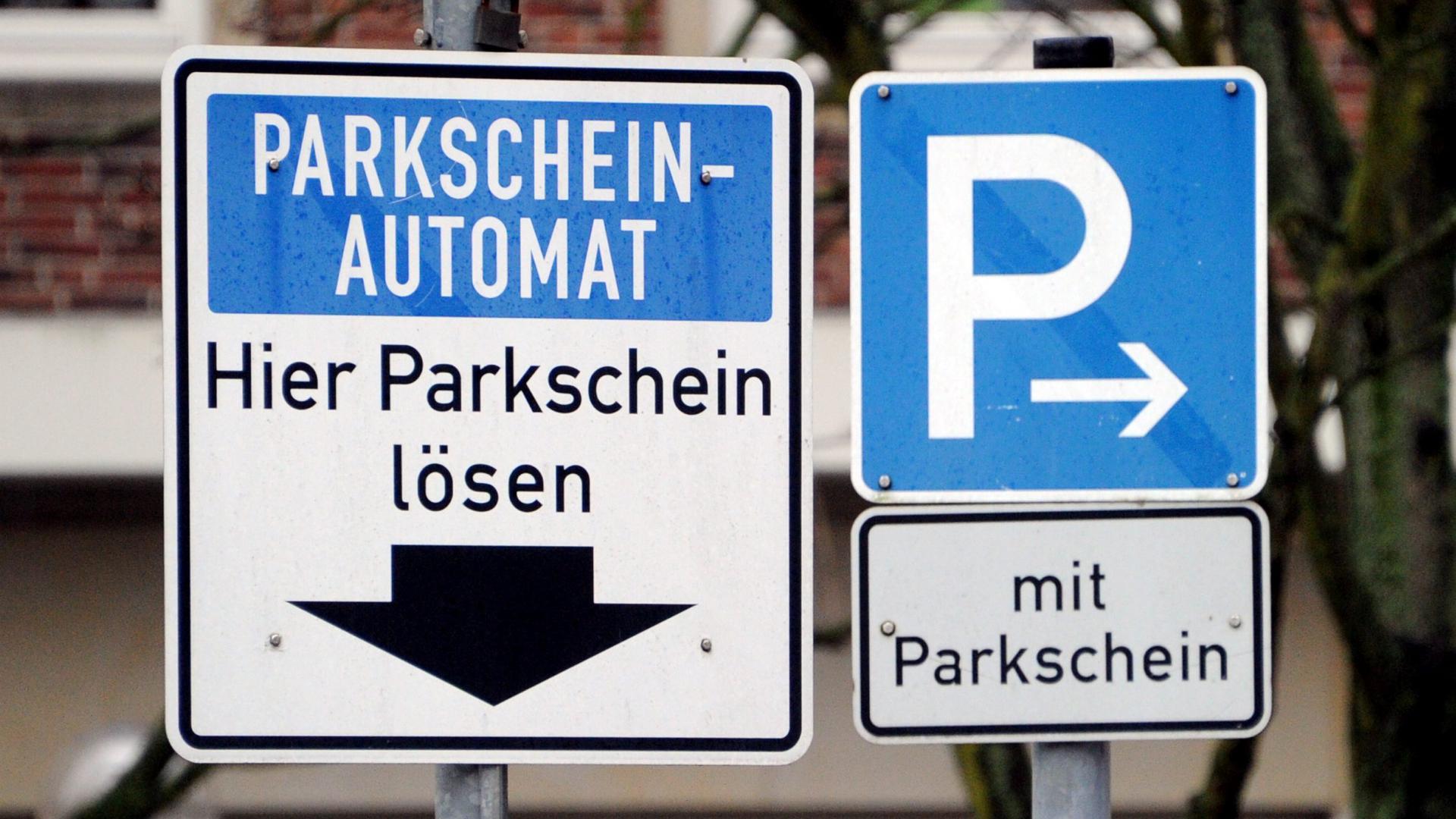 Schilder weisen am Donnerstag auf einen Parkscheinautomaten und gebührenpflichtige öffentliche Parkplätze hin. 