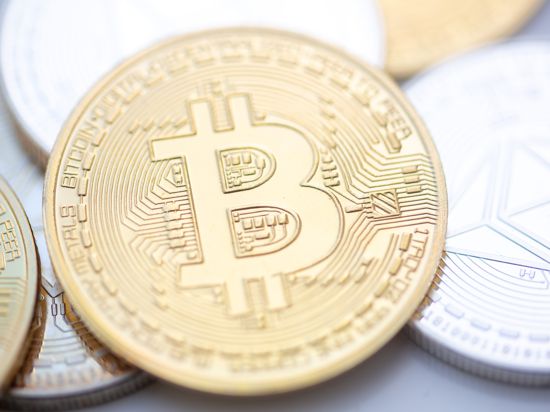 Bitcoin (M) und Ethereum-Münzen sind auf einem Tisch angeordnet. 