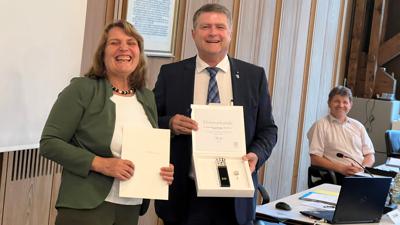 Birgit Halgato freut sich sichtlich über die Anerkennungen, die ihr Oberbürgermeister Martin Wolff überreicht. Auch Bürgermeister Michael Nöltner (im Hintergrund) sieht zufrieden aus.