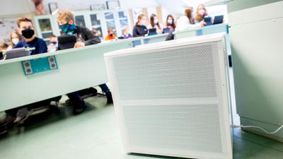 Ein Luftreinigungsgerät steht in einem Klassenzimmer.