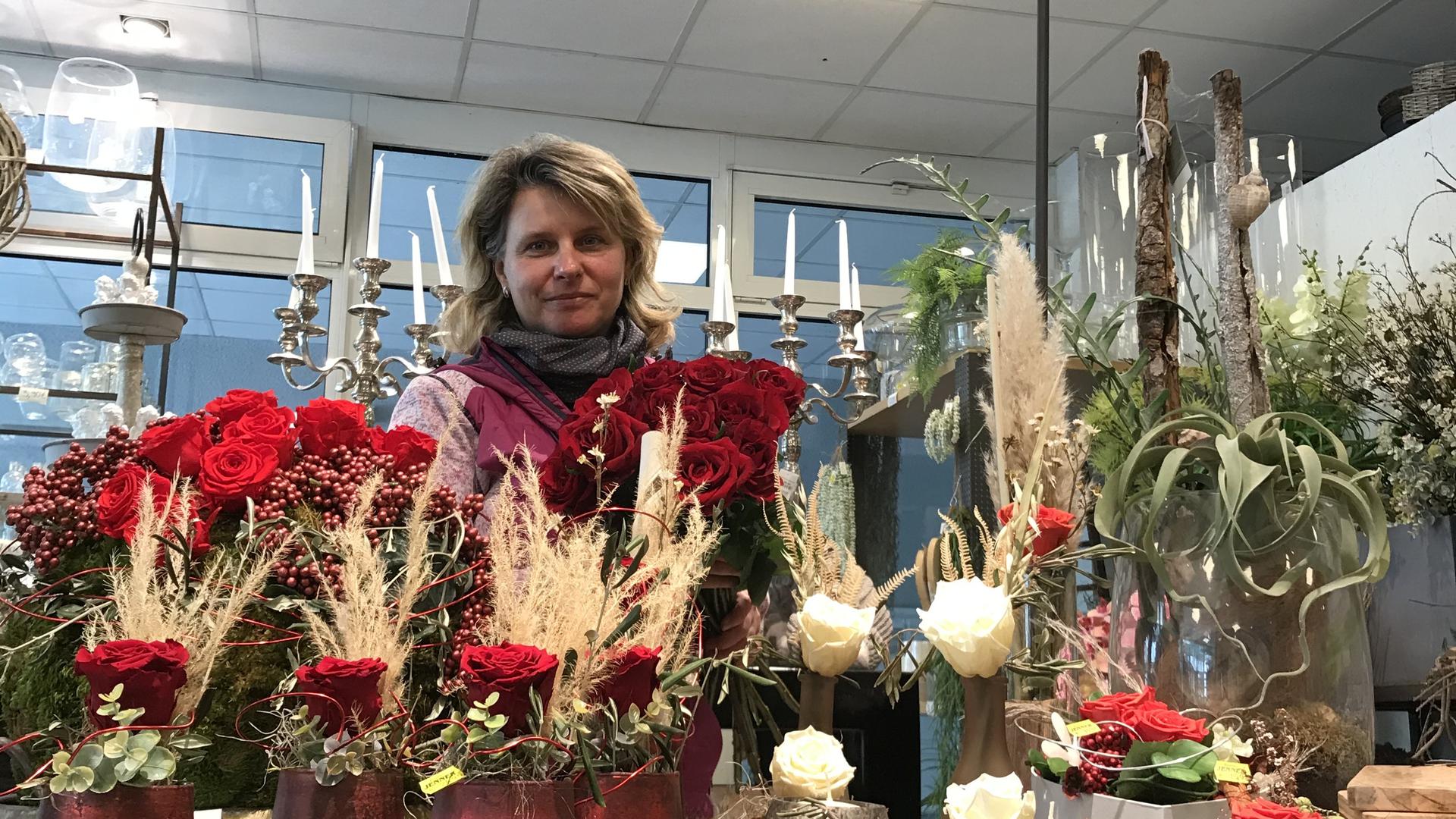 Stephanie Kreiter steht vor einem Stand mit Rosen in ihrem Blumengeschäft