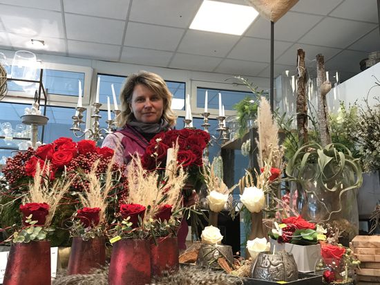 Stephanie Kreiter steht vor einem Stand mit Rosen in ihrem Blumengeschäft