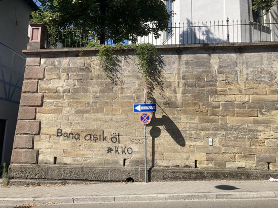 Auf einer Sandsteinmauer in Bretten steht in schwarzer Schrift: „Bana aşık öl #KKO“ 