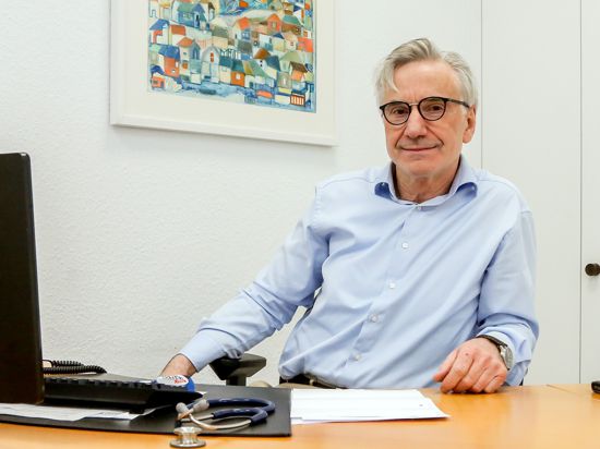 Ein Mann sitzt am Schreibtisch in seiner Praxis in Diedelsheim