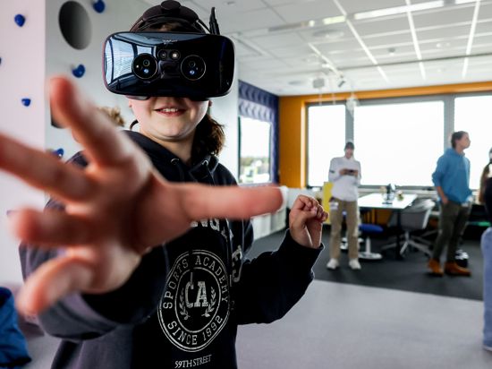 Ein Mädchen greift in der virtuellen Realität nach etwas, das es hinter der VR-Brille lebensecht vor Augen hat. Das ermöglicht tecspaze, eine neue digitale Werkstatt für Kinder und Jugendliche in Bretten kostenlos.