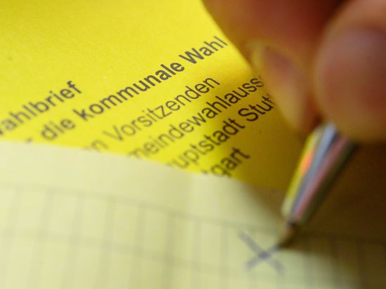 Ein Mann kreuzt einen Wahlzettel der Briefwahl für die Kommunalwahl in Baden-Württemberg an.