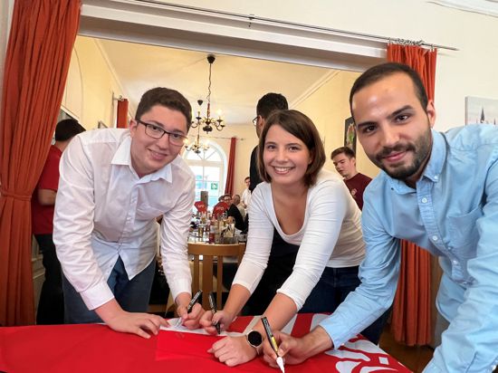 Nael Essafi, Magdalena Backes und Can Yildirim (von links) unterschreiben als Erste auf einer Flagge der SPD. Seit Mittwochabend bilden sie zusammen den Vorstand der Brettener Juso AG.