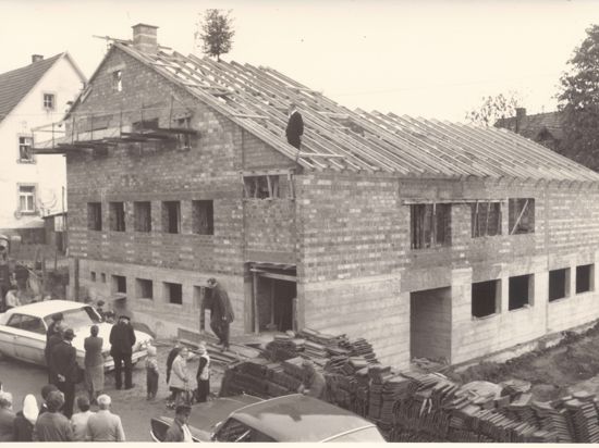 Das Bild zeigt den Kindergarten-Rohbau in Ruit von 1965. Auf dem Dach ist der damalige Ruiter Pfarrer Haas beim Richtfest zu sehen.