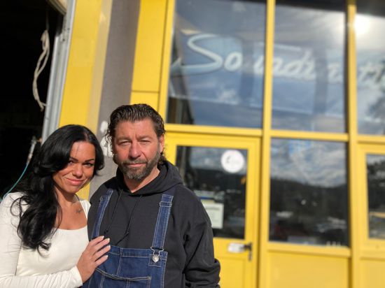 Marco Fanselau und seine Lebensgefährtin Katharina Ott stehen vor dem Firmengebäude von „Soundtastic“ in Bretten und schauen in die Kamera.