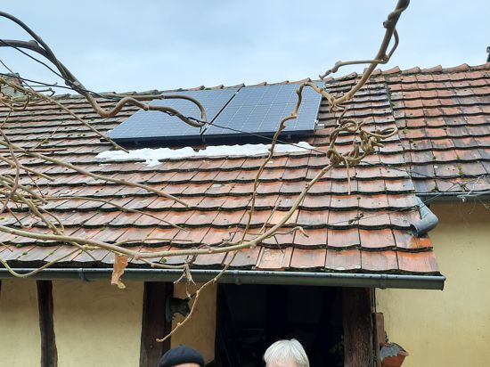 Mann und Frau vor Dach mit Solaranlage