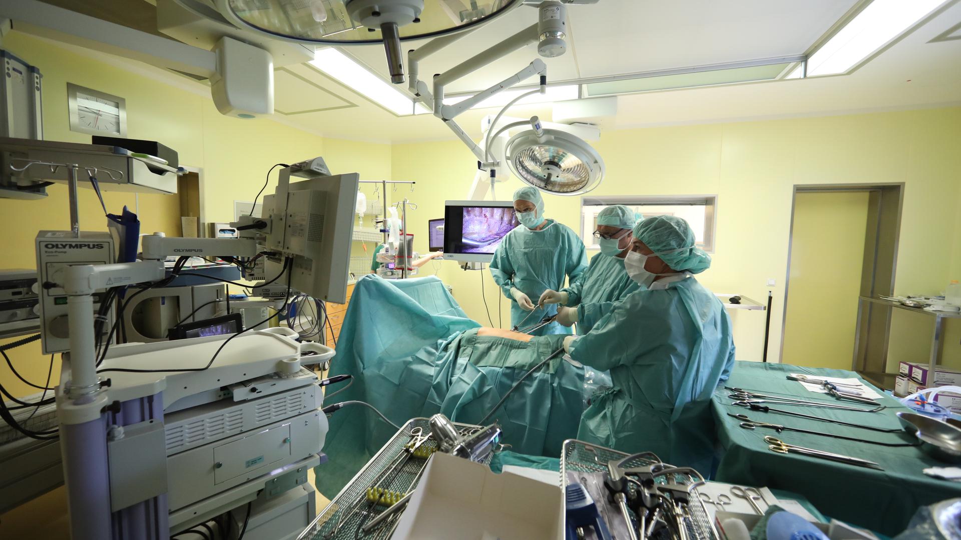 Ärzte und Schwestern stehen bei einer endoskopischen Operation in einem Operationssaal im SRH Waldklinikum. Hier wird bei einer Operation einem Patienten Lymphknoten an der Lunge entfernt. (zu "Ungefähr auf Vor-Corona-Niveau: Kliniken holen Operationen nach") +++ dpa-Bildfunk +++