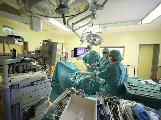 Ärzte und Schwestern stehen bei einer endoskopischen Operation in einem Operationssaal im SRH Waldklinikum. Hier wird bei einer Operation einem Patienten Lymphknoten an der Lunge entfernt. (zu "Ungefähr auf Vor-Corona-Niveau: Kliniken holen Operationen nach") +++ dpa-Bildfunk +++