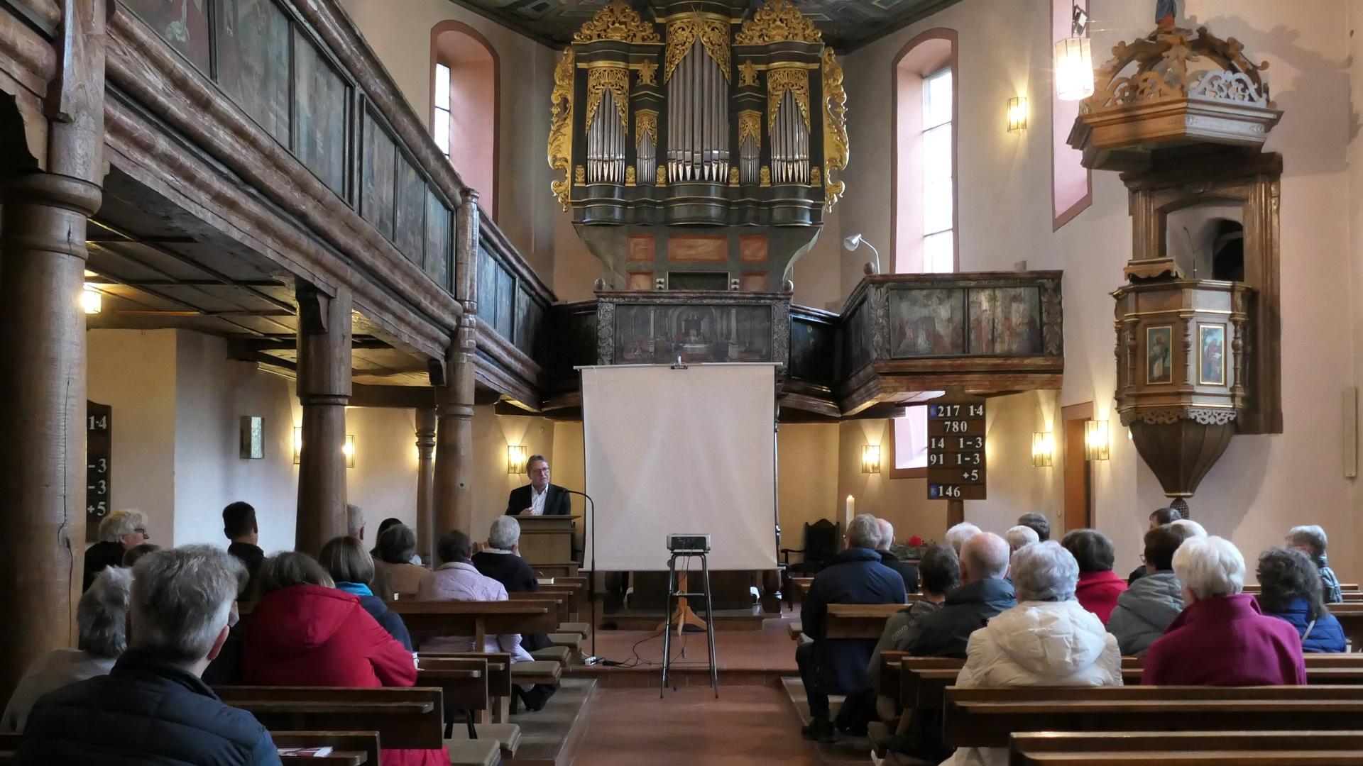 Pfarrer Dieter Becker-Hinrichs spricht zu Teilnehmern der Versammlung in der Kreuzkirche