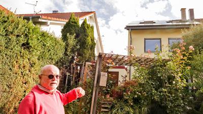 Ein Mann steht in seinem Garten in Bretten und deutet aufs Dach seines Hauses. Dort sind Module einer Anlage für Solarstrom angebracht seit zweieinhalb Jahren.