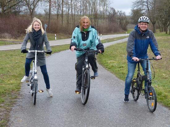 Sulzfelds Bürgermeisterin Sarina Pfründer, die Grünen-Landtagsabgeordnete Andrea Schwarz und Kürnbachs Bürgermeister Armin Ebhart sitzen auf ihren Fahrrädern.