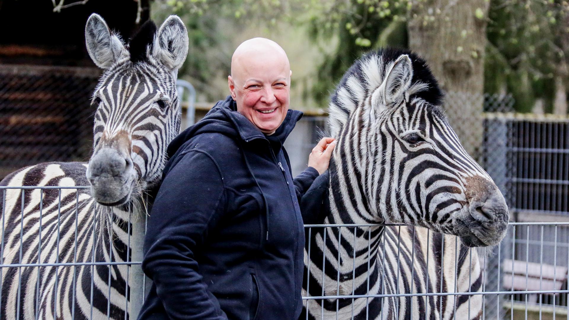 Tierpark-Chefin Annika Willig streichelt zwei Zebras.