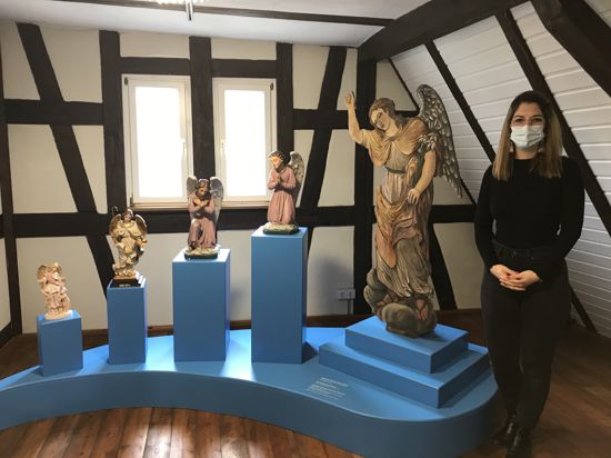 Linda Obhof steht im Schutzengelmuseum neben Engelsfiguren
