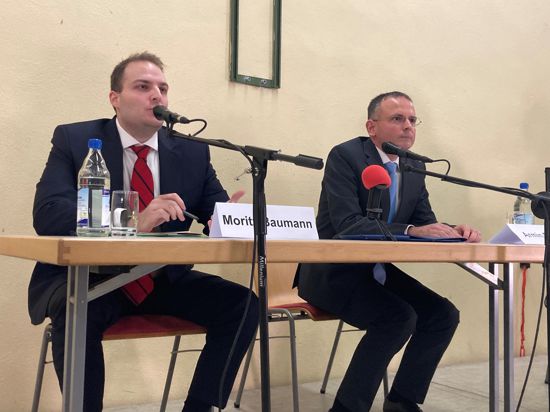 Moritz Baumann und Armin Ebhart sitzen an einem Tisch vor ihren Mikrofonen bei der Vorstellung der Bürgermeisterkandidaten in Kürnbach.