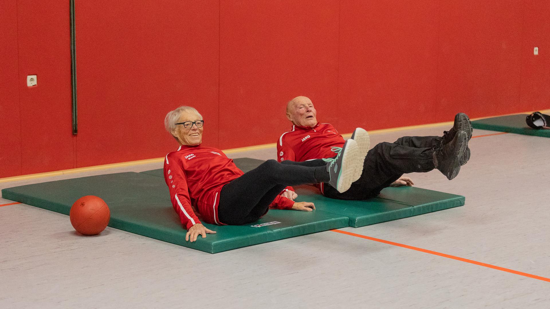 Wanda und Sepp Krempl vom SV Oberderdingen liegen auf Matten und strecken die Beine in die Luft.