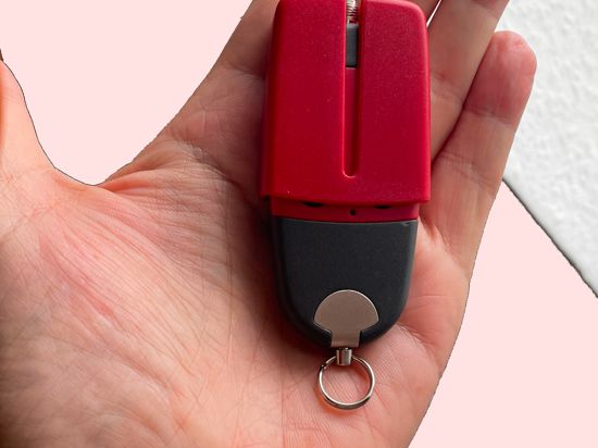 Ein Amok-Alarm-Sender, ein kleines rot-schwarzes Gerät liegt in der Hand des Firmenchefs von Meicnologic, die die Sender herstellt.