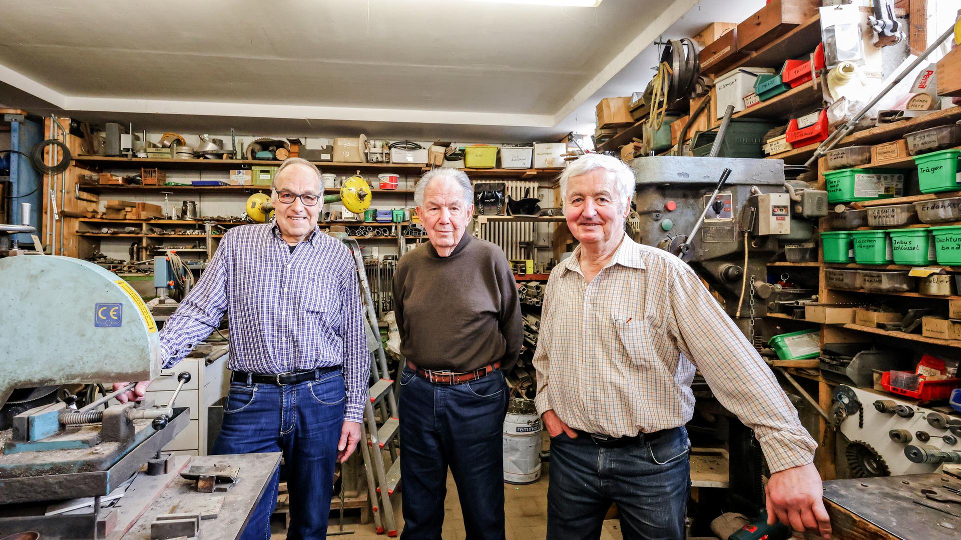 Drei Männer in Schlosserwerkstatt