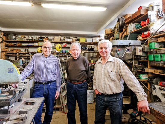 Drei Männer in Schlosserwerkstatt