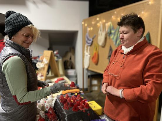 zwei Frauen unterhalten sich auf Weihnachtsmarkt
