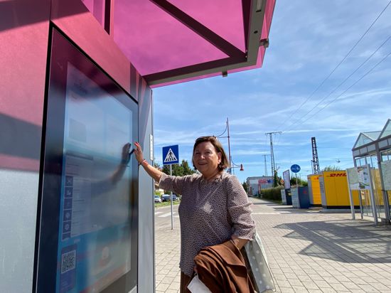Eine ältere Dame tippt am Bahnhof Bretten auf einen Bildschirm, um sich Informationen über ihre Zuglinie geben zu lassen.