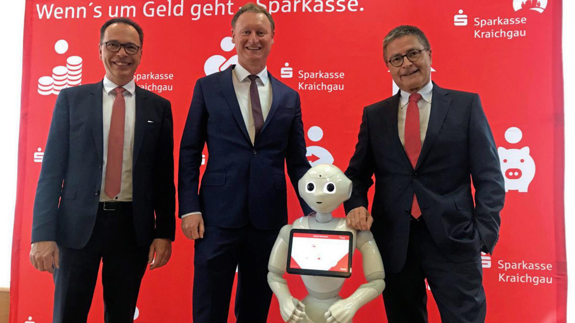 Das Sparkassen-Vorstandsteam: (von links) Michael Reichert, Norbert Grießhaber und Thomas Geiß mit ihrem digitalen Botschafter „Sparky“.