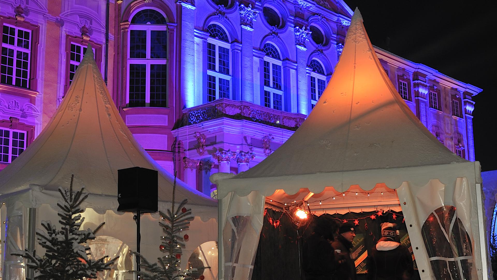 Die historische Kulisse des Barockschlosses erstrahlt in einem bezaubernden Lichtermeer und trägt zur weihnachtlichen Atmosphäre des Adventsmarktes bei.